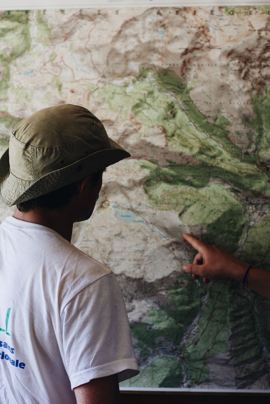 Travel writer holding a map on mountain trail